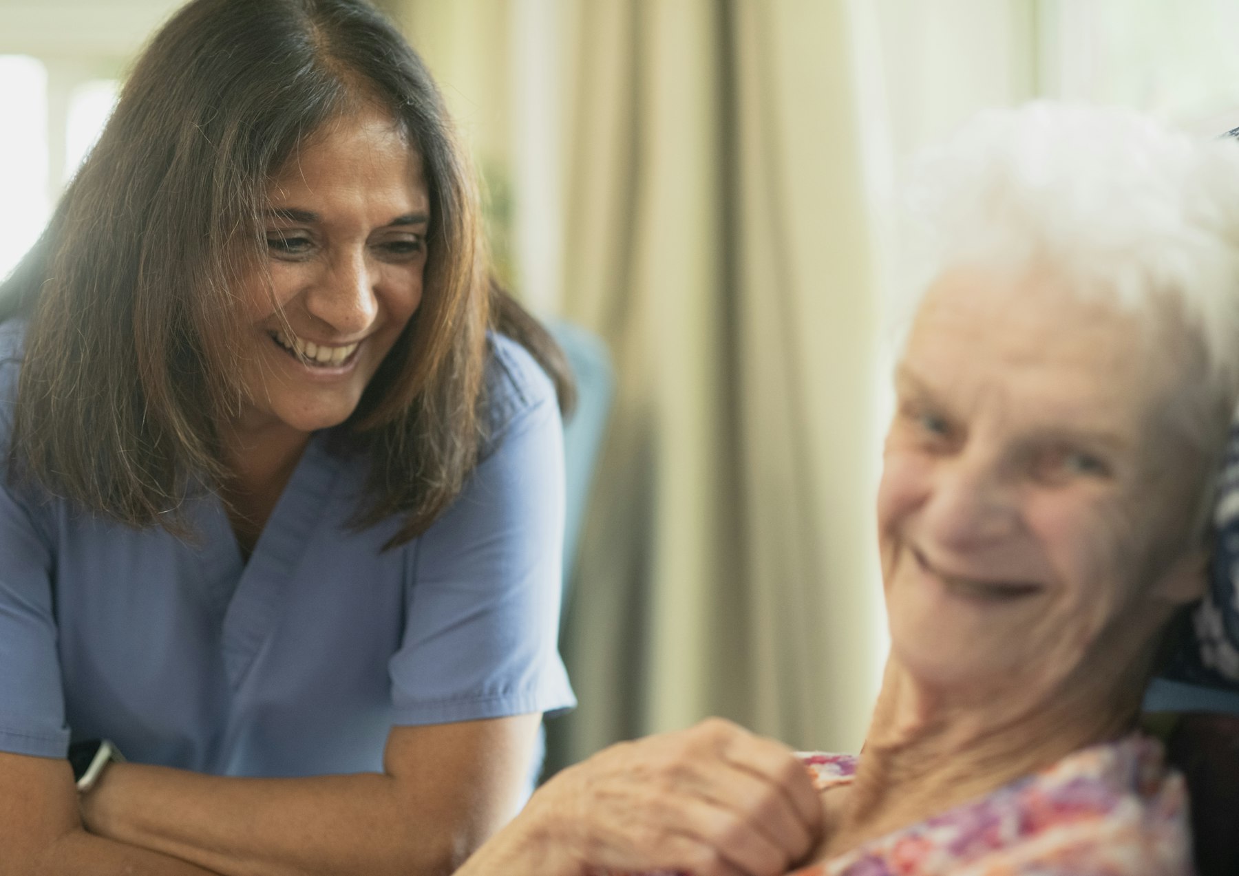 A care worker sharing a laugh with an older woman