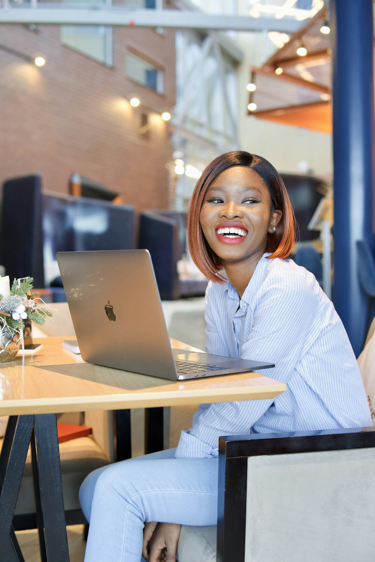 A woman smiling at her laptop in a bright office